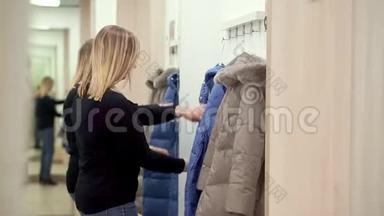一个在服装店的女人，在更衣室里穿着<strong>羽绒服</strong>